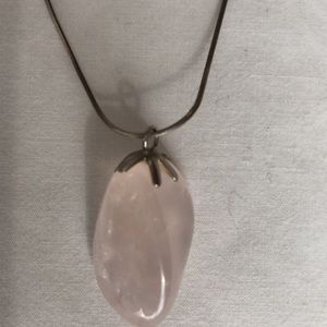 Clear white stone pendant on silver necklace.